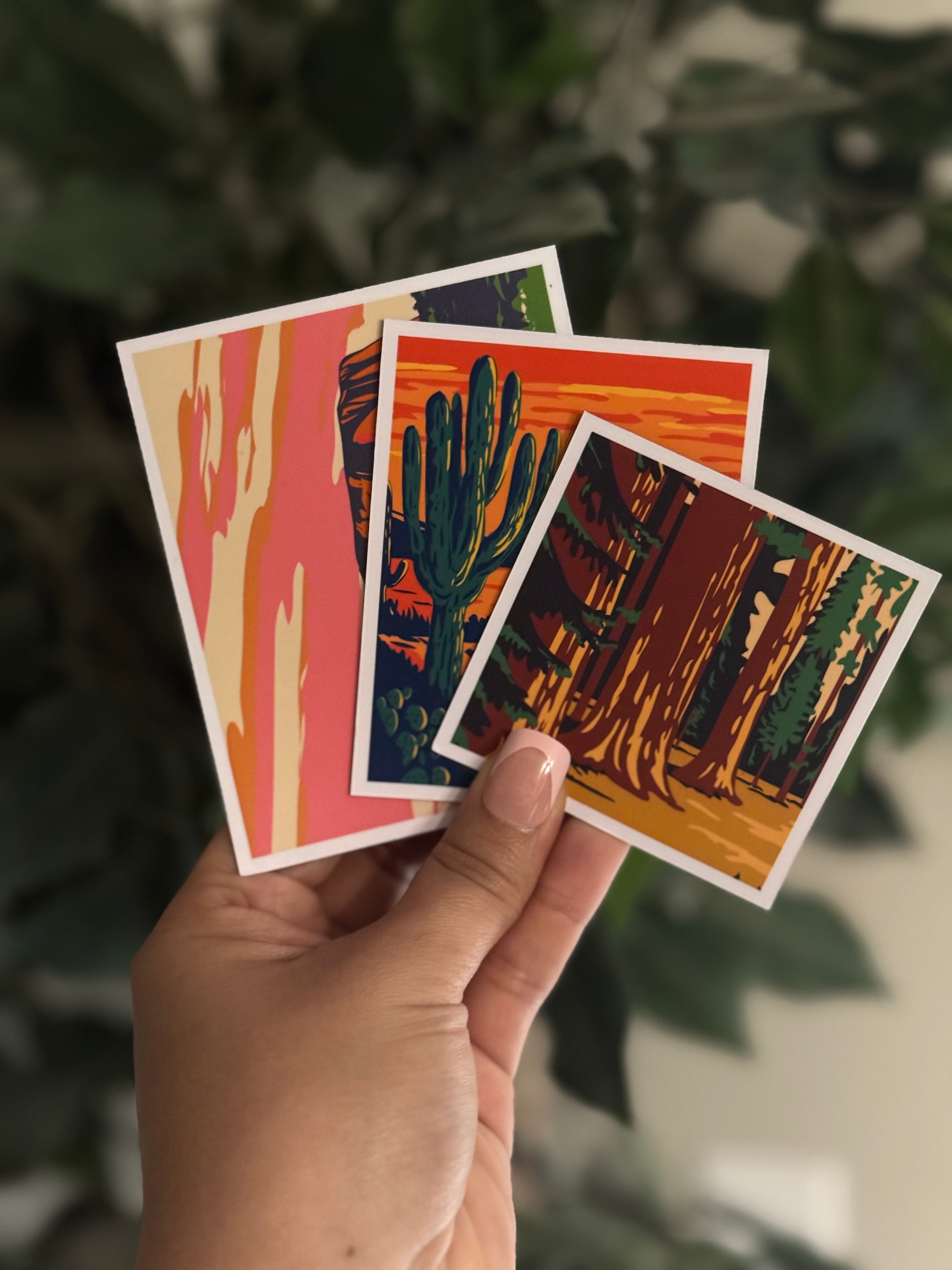 Hand holding all three classic sizes of personalized photo magnets with nature scenes and a blurred natural background