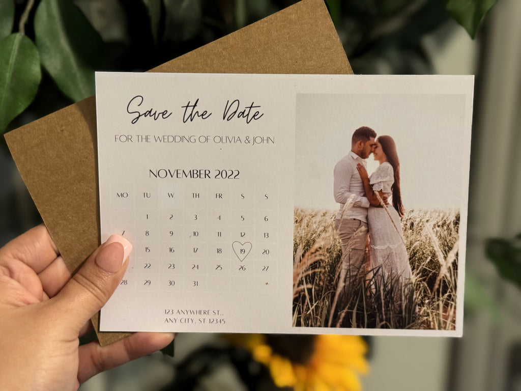 Personalized Magnetic Save the Date card with a couple in a field, held by a hand.